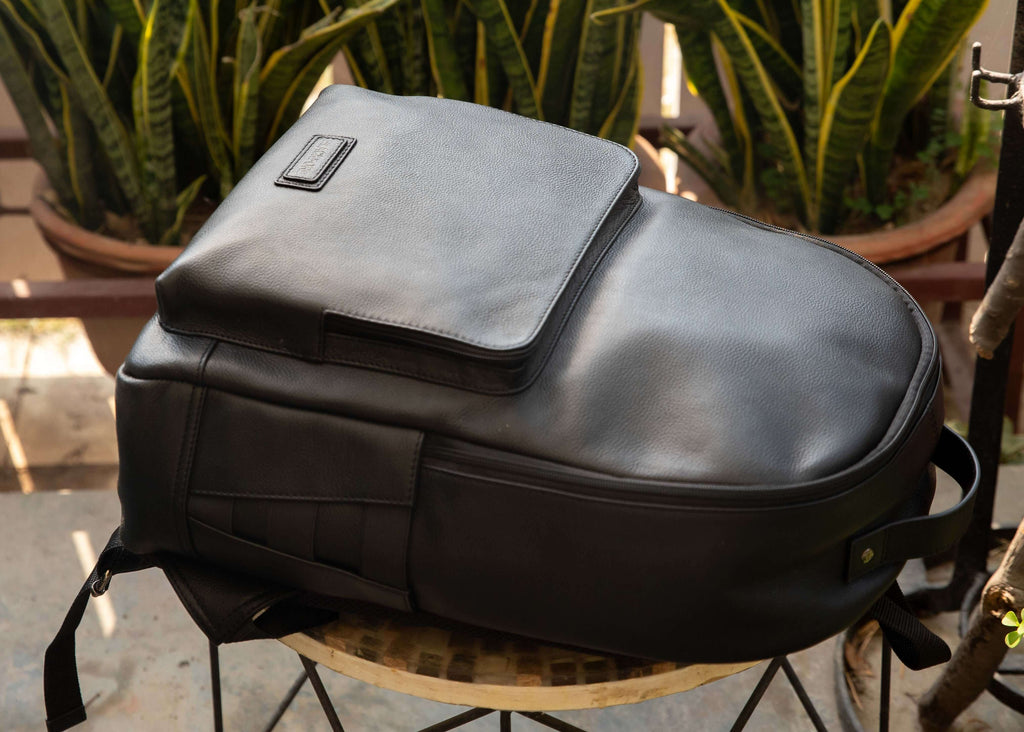 Black backpack on a chair with plants in the background